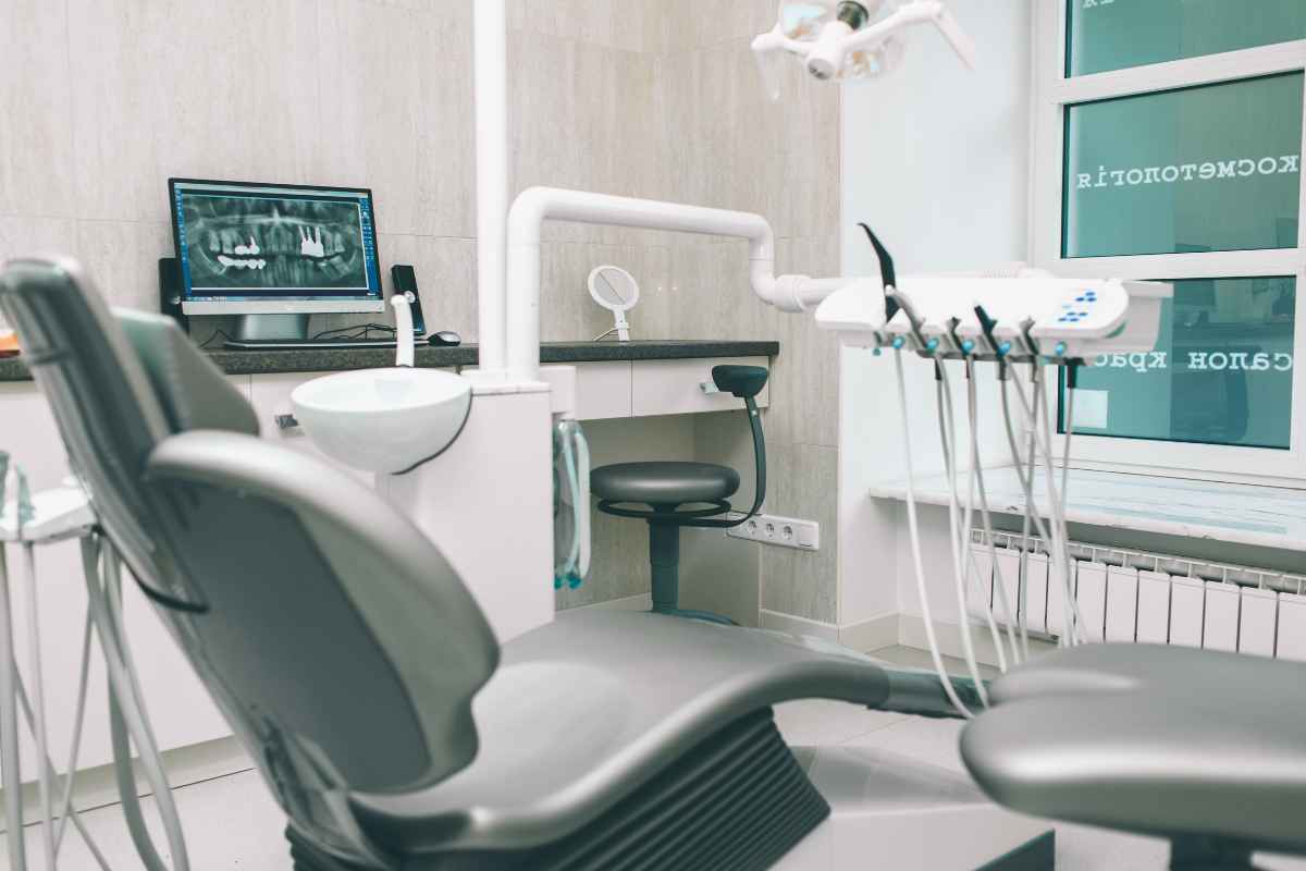 Consultorio dental con sillón, monitor de radiografías y equipo odontológico