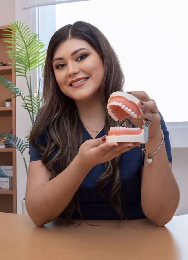 Dra. Gabriela Cuevas mostrando un modelo dental en su consultorio Dental Dream