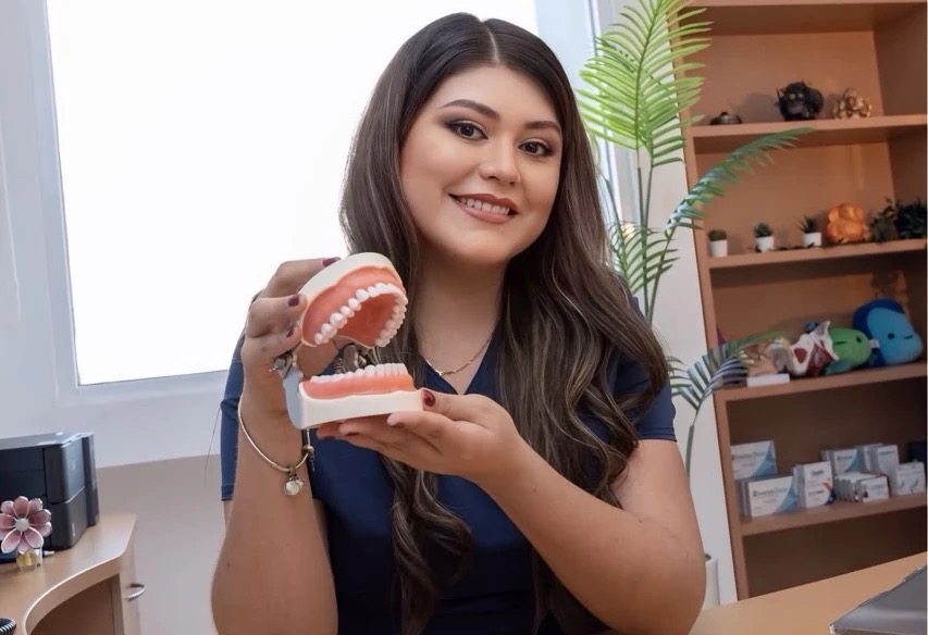 Dra. Gabriela Cuevas sosteniendo un modelo dental