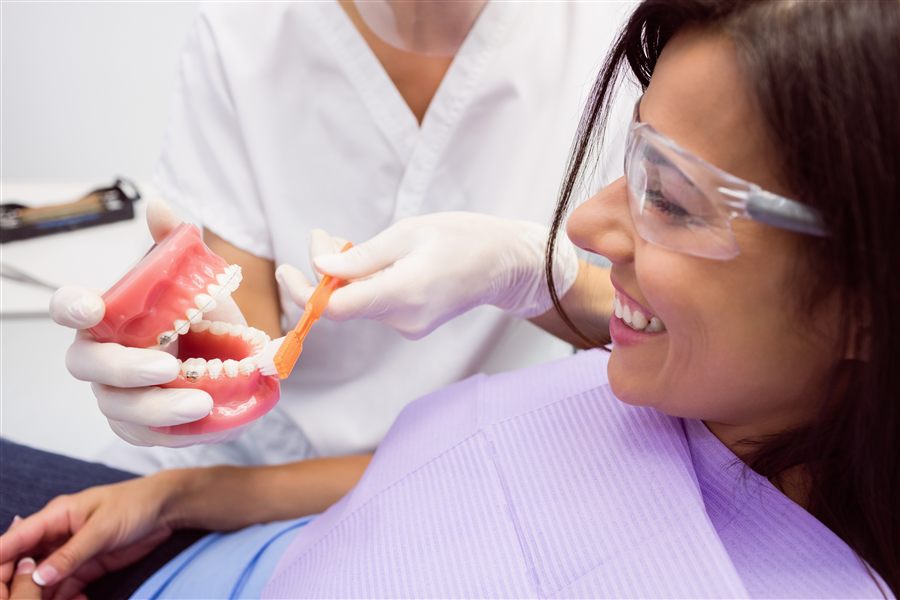 Dentista explicando un tratamiento con un modelo dental